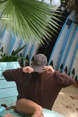 Buzo con capucha de tejido de punto abierto, color blanco roto, de corte oversize y manga larga con detalle de flecos en los puños.