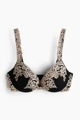 Soutien super push-up negro con detalles de encaje en tono beige en las copas y los breteles. Cuenta con aros, relleno y tirantes ajustables.