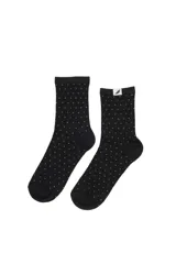 Par de medias de caña media color negro con estampado de lunares pequeños en hilo brillante. Incluye etiqueta decorativa en el borde superior.