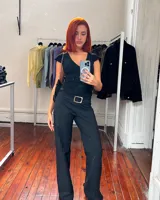 Pantalón negro de corte ajustado con cintura baja y hebilla plateada.