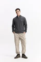 Buzo de punto con medio cierre frontal, cuello elevado y puños acanalados. Presenta un pequeño logo bordado en el pecho.