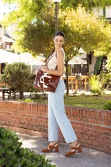 Sandalias de cuero color marrón, con dos tiras anchas sobre el empeine, pulsera con hebilla al tobillo y tacón bloque.