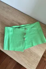 Top corto de cuero ovino color verde agua con cierre lateral con botones metálicos.