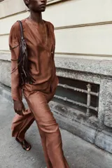 Chaqueta marrón con escote en pico, manga larga y cierre frontal cruzado con un botón.
