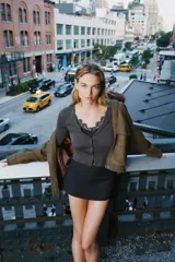 Conjunto de chaqueta de punto de cuello redondo y manga larga con cierre frontal de botones, combinada con un top interior de escote en pico con detalles de encaje.