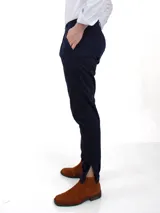 Pantalón de vestir azul marino, de corte recto, con bolsillos laterales y traseros. Se ajusta a la cintura con cinturón de cuero marrón.