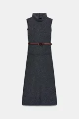 Vestido midi de cuello alto y manga sisa, confeccionado en tejido texturizado de color gris oscuro. Presenta un diseño entallado con costura a la cintura, acabados deshilachados y cierre posterior con cremallera oculta. Incluye un cinturón fino de cuero sintético en color marrón con hebilla metálica dorada.