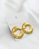 Aros colgantes dorados con forma circular irregular y textura labrada.