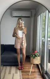 Conjunto color naranja compuesto por un chaleco sin mangas con solapas y un short de tiro alto con elástico en la parte trasera.