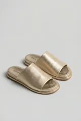 Sandalias planas negras tipo slide, con capellada ancha de pelo corto. Tienen suela de caucho expandido y base plana de 3 cm de altura.