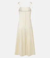Vestido midi color amarillo pálido, con escote recto y busto con recortes. Posee breteles finos ajustables con lazo y cierre trasero de cremallera.