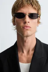 Blazer negra de corte relaxed fit, confeccionada en tejido con mezcla de viscosa. Tiene cuello con solapas de pico, manga larga con puños abotonados, bolsillos de vivo en pecho y cadera, abertura en el centro de la espalda y cierre frontal cruzado con botones.