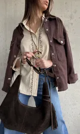 Camisa beige de tejido liviano y calce relajado, con manga larga y detalle de puntilla y bordado en contraste que recorre el frente.