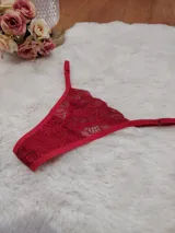 Microtanga de encaje rojo con diseño floral, laterales ajustables y terminaciones con elástico.