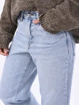 Jean de corte mom fit en color celeste claro, tiro medio-alto, con diseño clásico de cinco bolsillos y pernera recta ligeramente cónica.