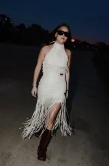 Pollera midi de cuero color hielo, de silueta al cuerpo y con detalle de flecos largos en la parte inferior.