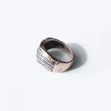 Anillo de diseño ancho elaborado en combinación de plata y oro, con tres bandas centrales decoradas con circonias brillantes.