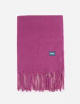 Bufanda de textura suave en color fucsia, con flecos en los extremos y una pequeña etiqueta rectangular decorativa con diseño a cuadros.