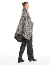 Ruana de Jones New York con estampado animal print en tonos blanco y negro. Presenta un diseño envolvente con cuello alto y cierre frontal mediante un botón tipo trenca.