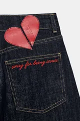 Jeans de tiro alto confeccionados en denim azul oscuro, con diseño barrel de pernera holgada que se estrecha hacia los tobillos. Cuenta con cinco bolsillos, trabillas para cinto y cierre frontal con cremallera y botón.