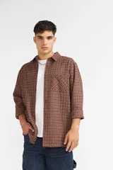Camisa Quiksilver modelo Fresno a cuadros, manga larga, con bolsillo frontal aplicado en el pecho y cierre de botones.