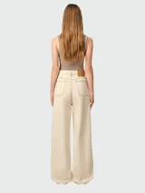 Pantalón de jean estilo wide leg en color beige, con tiro alto, cierre frontal con botón y bolsillos laterales.