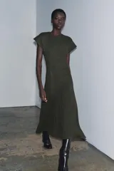 Vestido largo de punto color verde oscuro, con cuello redondo, manga corta y bajo en evasé.