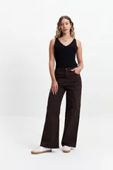 Pantalón de jean azul oscuro, de corte wide leg y tiro alto, con costuras a la vista y cierre frontal con botón.