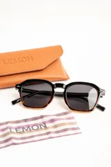 Lentes de sol polarizados con armazón negro de diseño geométrico y lentes oscuros.