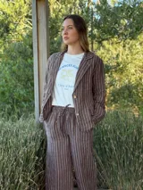 Blazer azul marino con rayas verticales blancas, confeccionado en lino italiano. Tiene botones de coco, solapas clásicas y bolsillos delanteros.