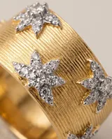 Anillo ancho de bronce con baño de oro, acabado texturizado tipo malla y detalles de estrellas incrustadas con circonias.