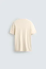 Camiseta de punto de corte regular, confeccionada en una mezcla de viscosa. Presenta cuello redondo y mangas cortas con acabados en rib.