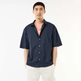 Camisa de manga corta azul marino confeccionada en popelín, con cuello camisero clásico y cierre frontal de botones.