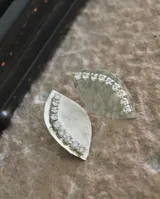 Par de aros colgantes con forma de hoja, hechos en alpaca color plateado y decorados con una hilera de strass.