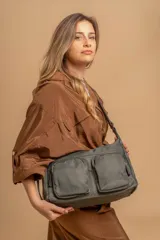 Bandolera de tafeta impermeable color beige, con dos bolsillos frontales con cierre y correa regulable. Diseño práctico y liviano ideal para uso diario.