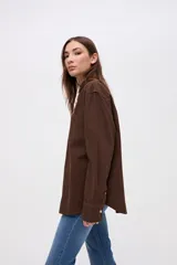 Sobrecamisa de algodón color marrón, con cuello solapa, cierre frontal de botones y bolsillos frontales en el pecho.