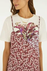 Vestido midi fluido de corte recto, con tirantes finos y diseño estampado floral en tonos bordó y lila.