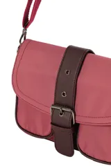 Bandolera urbana de diseño compacto, color negro, con solapa frontal decorada con una hebilla central, bolsillos frontales y correa ajustable para llevar al hombro o cruzada.