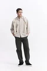 Camisa de popelina a cuadros, color celeste y blanco, de manga larga y corte holgado. Presenta un bolsillo frontal y cartera abotonada.