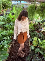 Buzo tejido color crudo con mangas largas y calado en el frente.