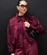 Campera bomber de gamuza sintética color bordó, con cuello clásico, cierre frontal, hombros caídos y puños ajustados.