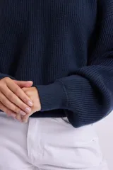 Buzo de punto azul marino, de mangas largas abullonadas y cuello redondo.
