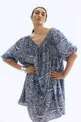 Vestido corto de manga globo, con escote amplio elástico y ajuste de tiras con cuentas en el centro del busto. Presenta un estampado paisley en tonos de azul.