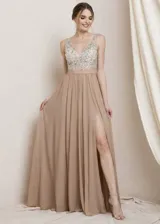 Vestido largo de fiesta con cuerpo superior sin mangas bordado en pedrería brillante y falda fluida de gasa con tajo lateral profundo.