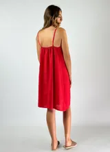 Vestido corto rojo de lino con breteles finos y escote en V con frunce y cordón ajustable.