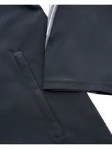 Campera deportiva Under Armour con capucha, confeccionada en tejido impermeable y transpirable con tecnología UA Storm. Presenta cierre frontal completo, bolsillos laterales con cremallera y detalles reflectantes en las mangas con diseño de líneas verticales.