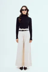 Pantalón wide leg de tiro alto en color beige, con costuras pespunteadas en contraste, pinzas frontales y botamanga ancha.