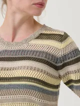 Remera de tejido calado a rayas horizontales en tonos beige, marrón, verde y gris. Tiene cuello redondo con borde ondulado y mangas cortas con borde ondulado.