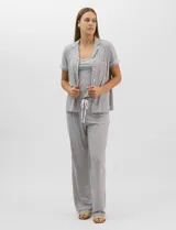 Set de pijama de tres piezas en color verde menta con estampado floral sutil, compuesto por una camisa de manga corta con botones, una musculosa básica y un pantalón largo de corte recto con cordón ajustable en la cintura.