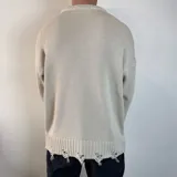 Sweater de tejido de punto color blanco, con diseño de cuello redondo y detalles de roturas desgastadas en el cuello, puños y ruedo.